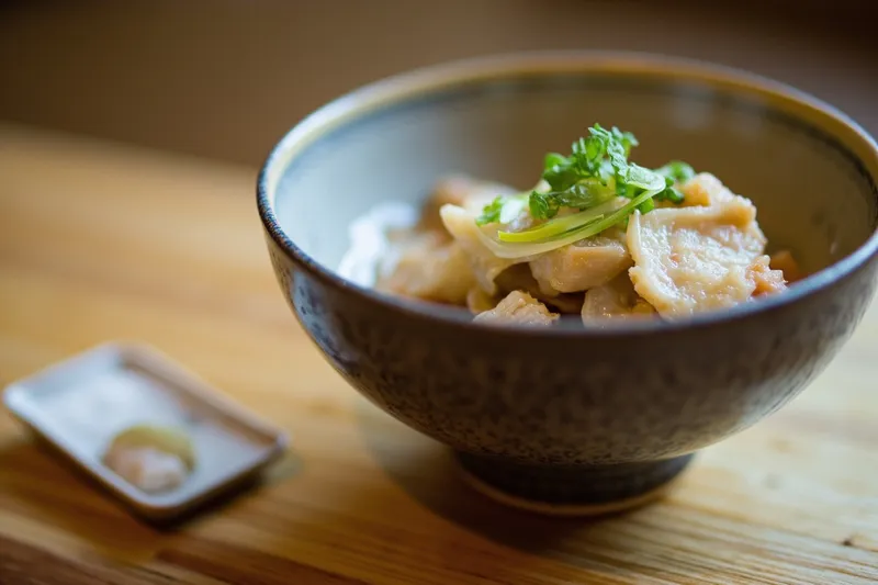 Small ceramic bowl on a bare wooden table, sized for a modest portion.