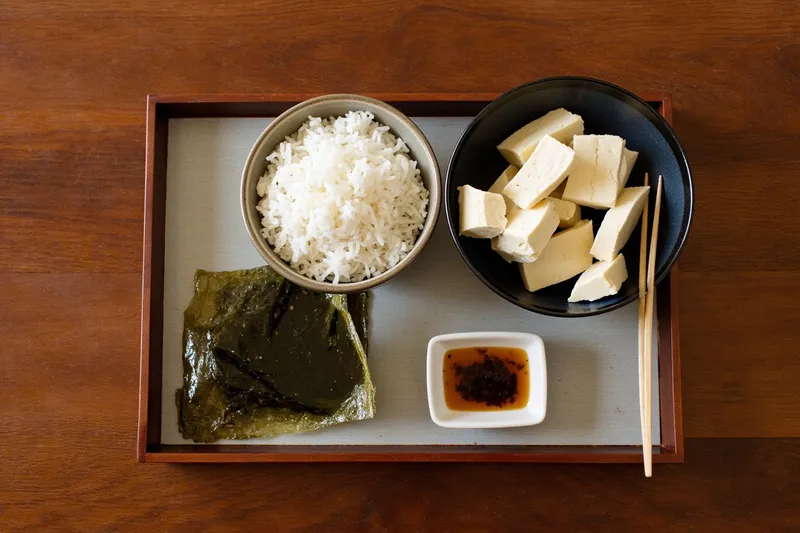 Japanese tofu and rice meal set with seaweed on a wooden tray
