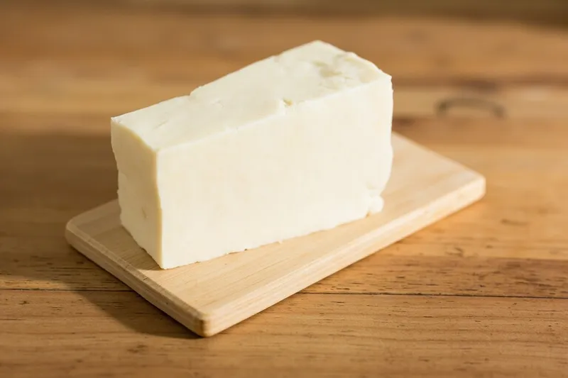 Block of fresh white tofu on a wooden board