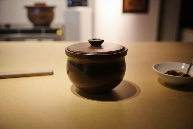 Japanese donabe clay pot with its lid on a kitchen surface