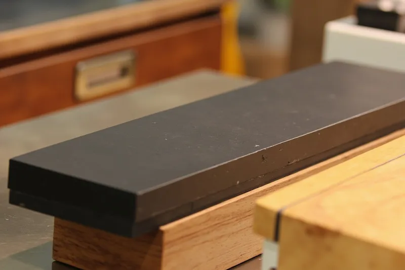 Japanese sharpening whetstone resting on a wooden base