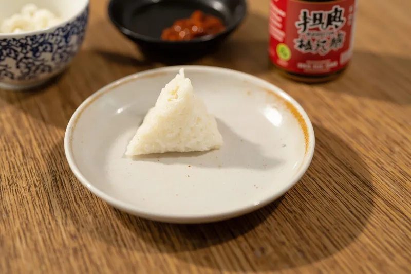 Triangular onigiri rice ball with nori on a ceramic plate