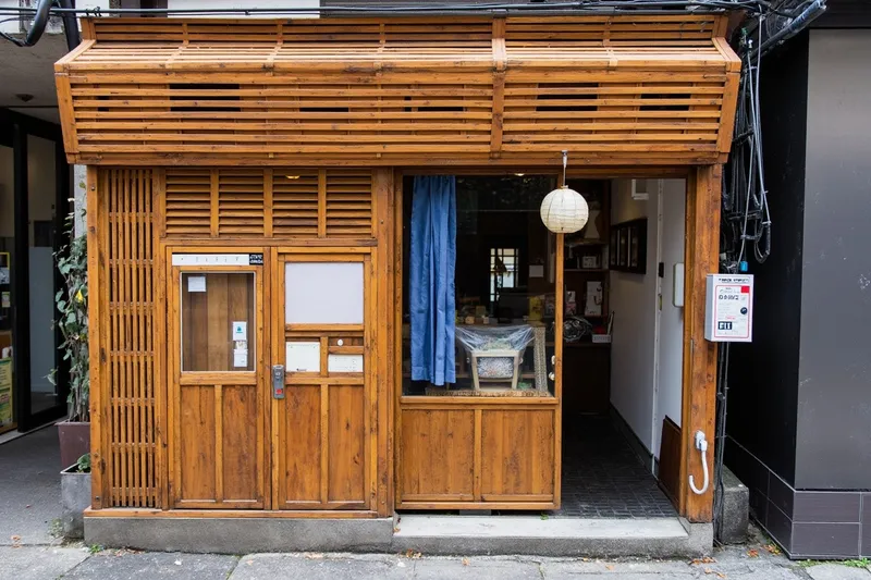 Wooden storefront of Tempura Kanda Honten in Kanda with a blue noren curtain at the entrance