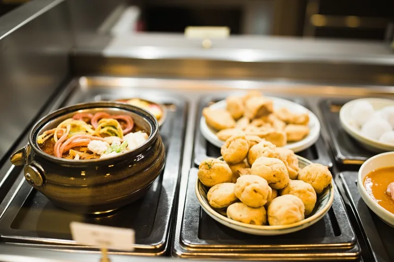 Hot counter with simmering oden pot and steamed buns in a Tokyo konbini