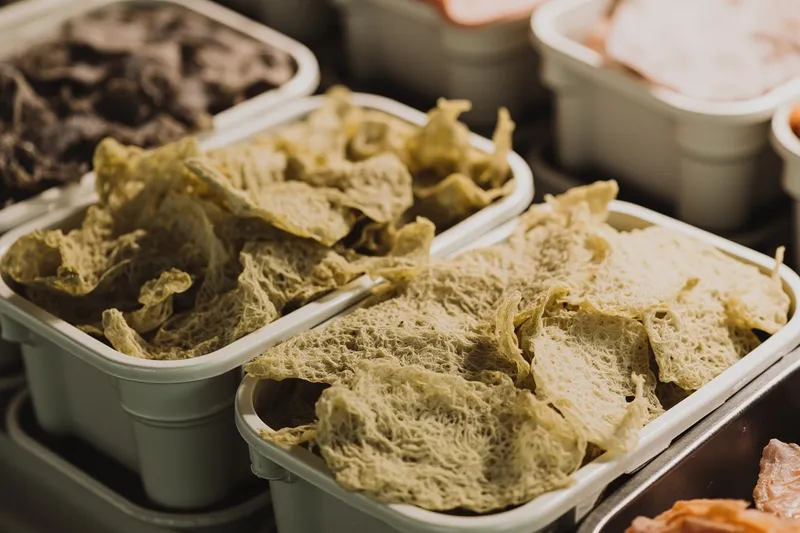 Bundles of dried kombu and packs of dried bonito flakes in open tubs at a Tsukiji dry goods stall